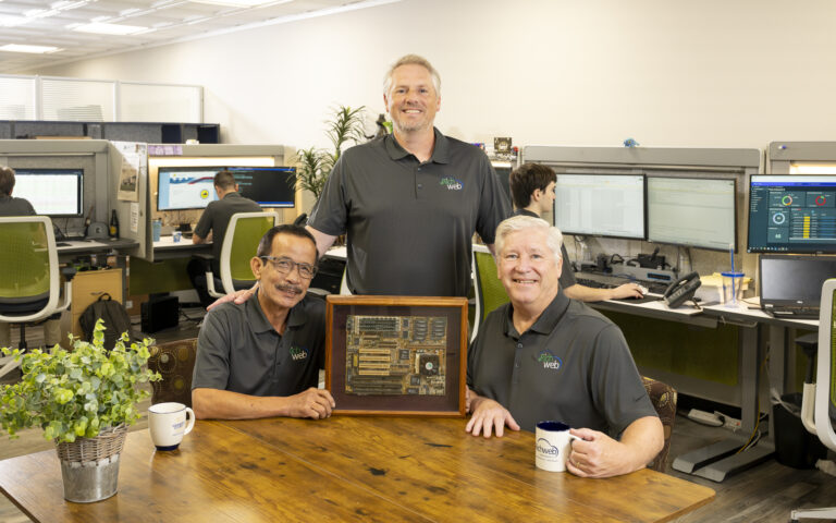 Richweb founders with the framed motherboard from the company's first server